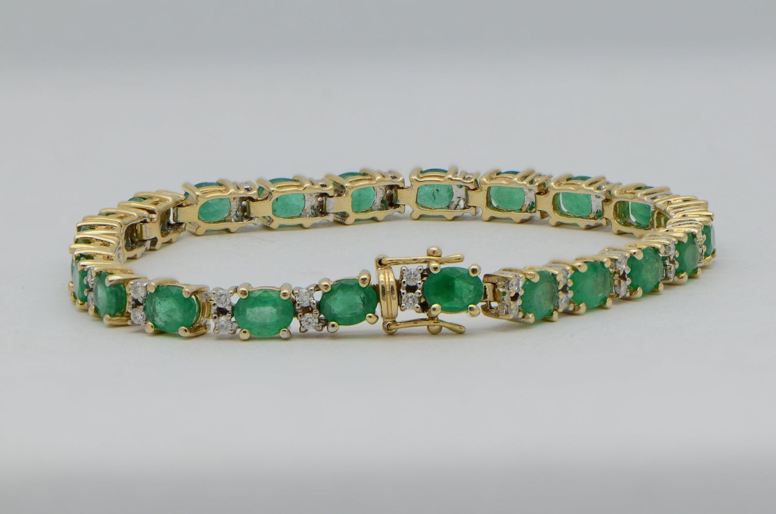 "BRAC01355" Oval Emerald and Round Diamond Yellow Gold Tennis Bracelet